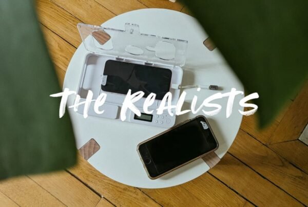 a photo showing a small round white table with two phones on it, one in a "phone cage"